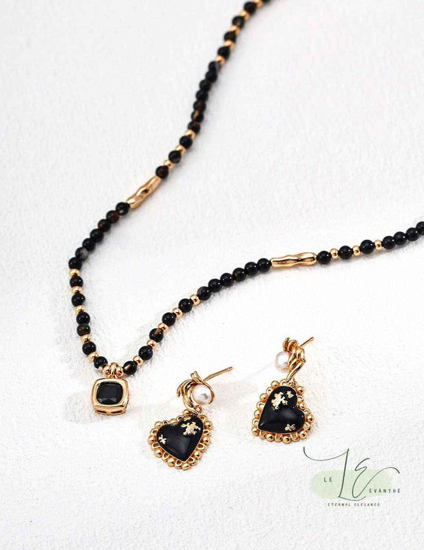 Model wearing Black Agate Heart Earrings, highlighting the secure French wire backs".