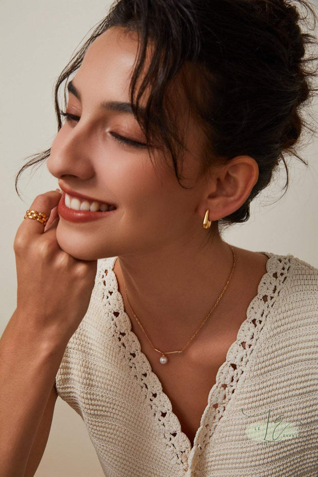 Close-up of Geometric Hoop Earrings showcasing precision-cut edges and the unique handbag-shaped design. The 18K gold plating adds warmth to the sterling silver base for versatile styling.