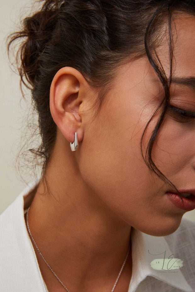 Model wearing the Geometric Hoop Earrings, demonstrating how the handbag-shaped hoops sit perfectly on the earlobe. The hypoallergenic posts ensure comfort for sensitive ears.