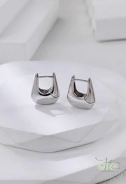 Side view of Geometric Hoop Earrings highlighting the dimensional handbag structure. The open-back design keeps them lightweight while making a bold statement.