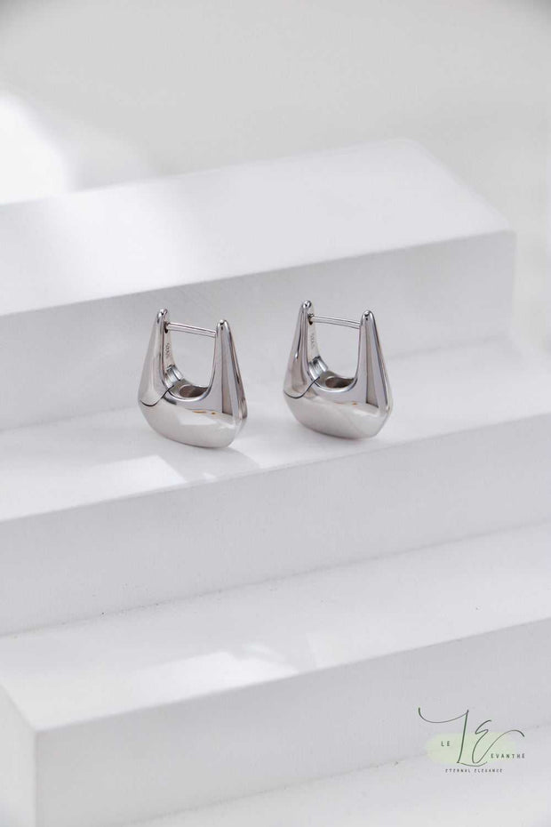 Flat-lay styling of Geometric Hoop Earrings paired with minimalist jewelry - the angular hoops add edge to both casual and formal outfits.