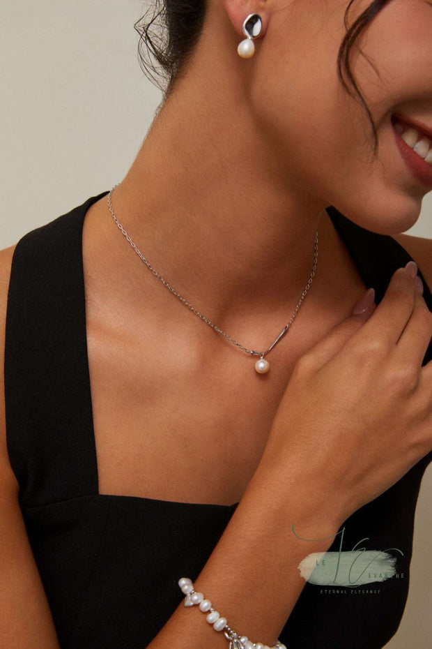 Flat-lay styling of the Minimalist Pearl Pendant Necklace paired with other dainty jewelry. The pearl’s neutral tone complements both warm and cool outfits effortlessly.