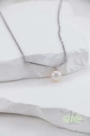 Close-up of the Minimalist Pearl Pendant Necklace’s pearl, showcasing its flawless symmetry and lustrous surface. The 18K Gold bail adds a subtle touch of luxury to the sterling silver chain.